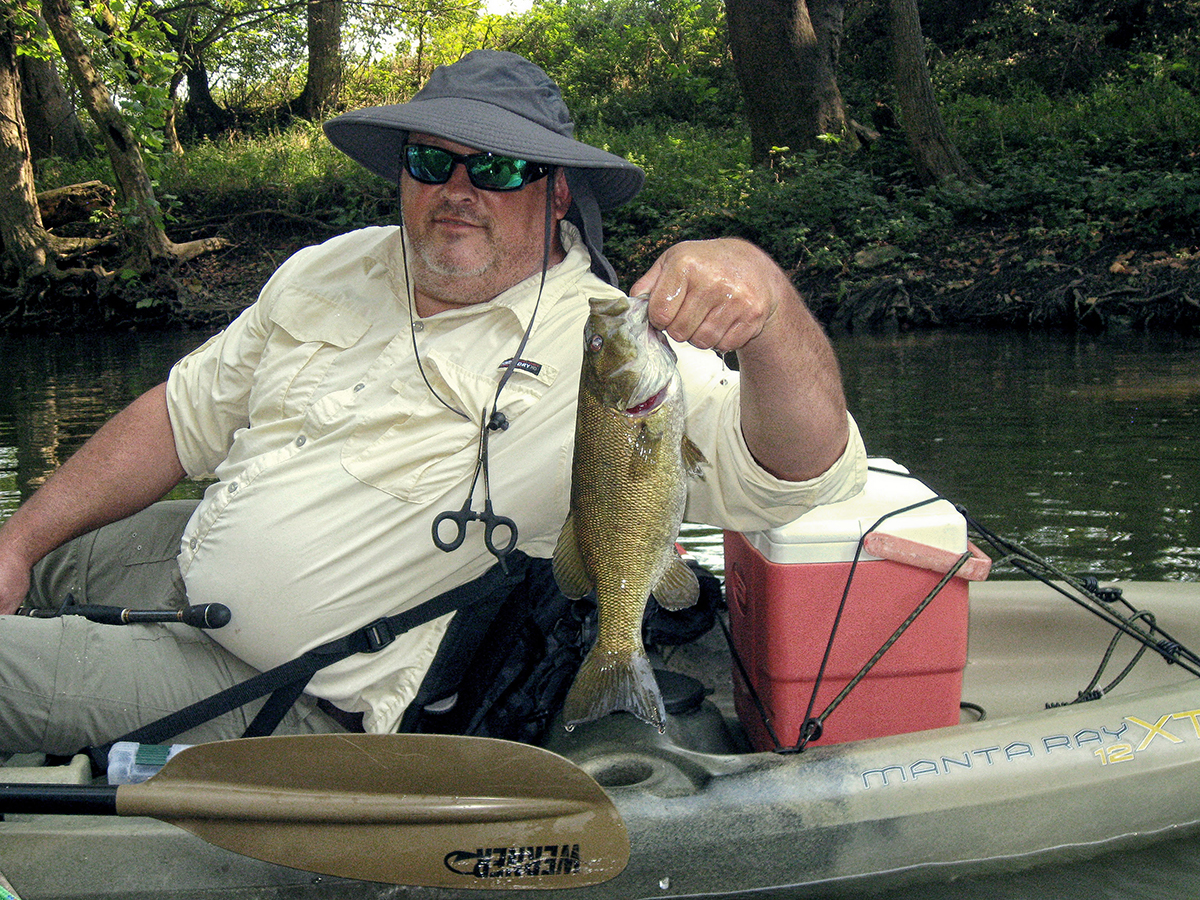 Aaron Boggs, director of horticulture and natural areas for the Parklands of Floyds Fork, holds a fat smallmouth bass