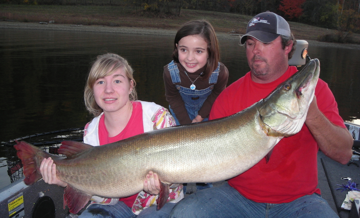 state record muskie being held by two women and a man